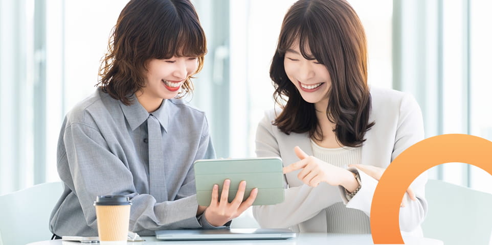タブレットを見て笑顔で話す2人のスタッフ